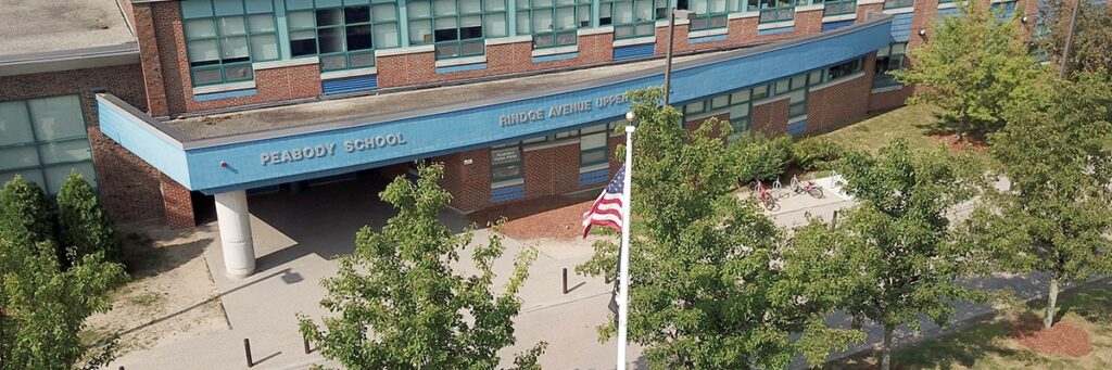 Aerial view of Peabody and Ringe Avenue Upper School, a brick building with blue trim reading the names of the school.