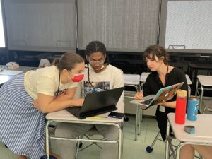 A student in the Cambridge Harvard Summer Academy works with student teachers on a proposal for neighborhood improvements.
