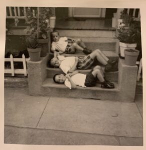 A summer day in the backyard on Allston Street with Louis Fenerlis reclining on the top step, his brother Peter on the middle one and cousin Jimmy Raftelis (whose family owned the house and lived upstairs) on the bottom. 