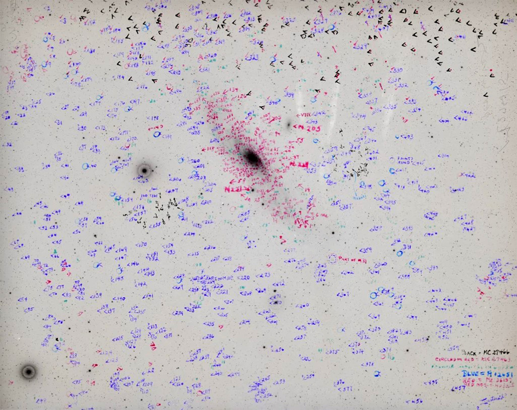 A swarm of markings on plate MC27415 made by Muriel Mussells Seyfert, a Woman Astronomical Computer. Her notations point to potential galaxies, including the great spiraling Andromeda near the center of the image. 