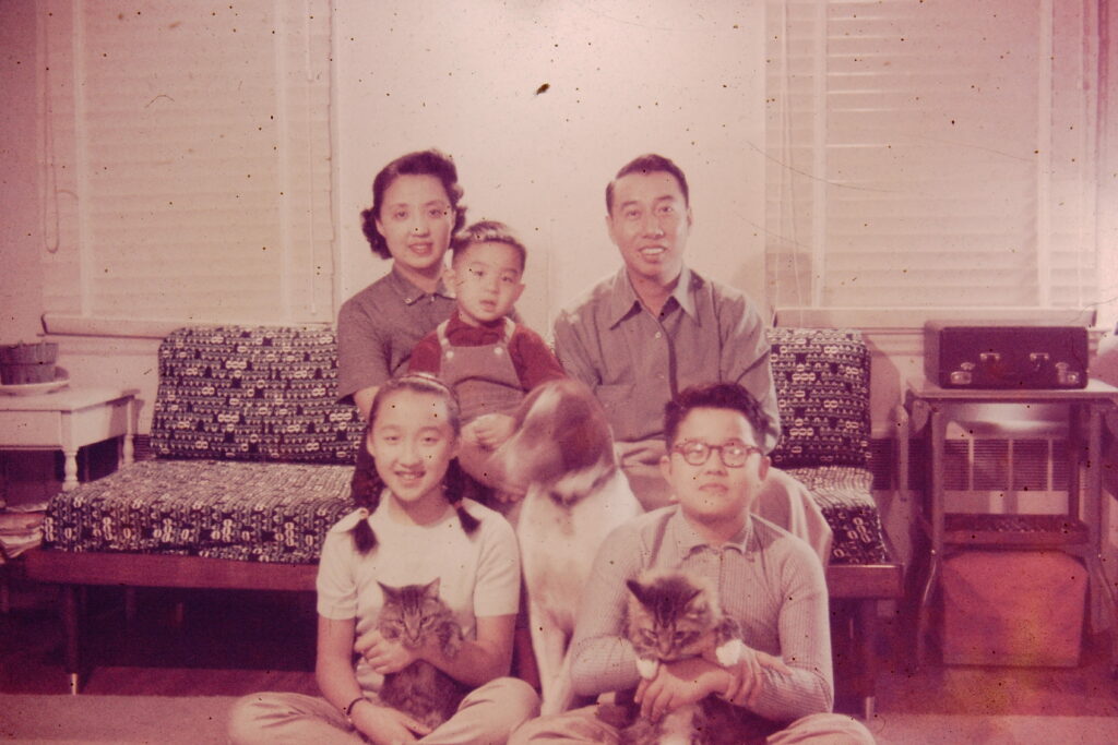 Family photo of two adults with three children, a dog, and two cats