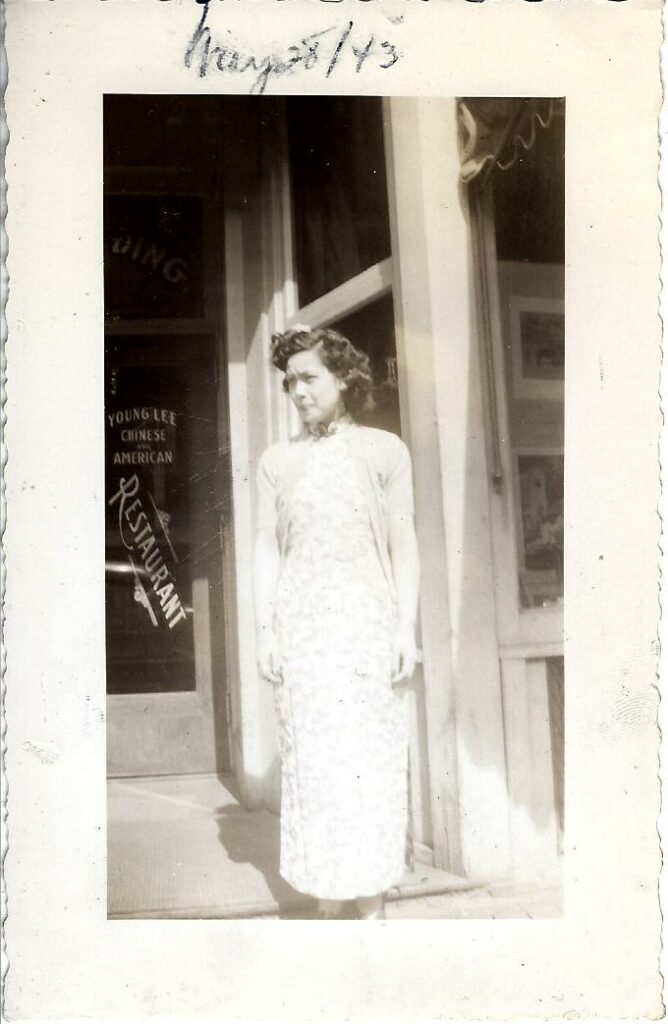 Woman in white dress standing in front of a building