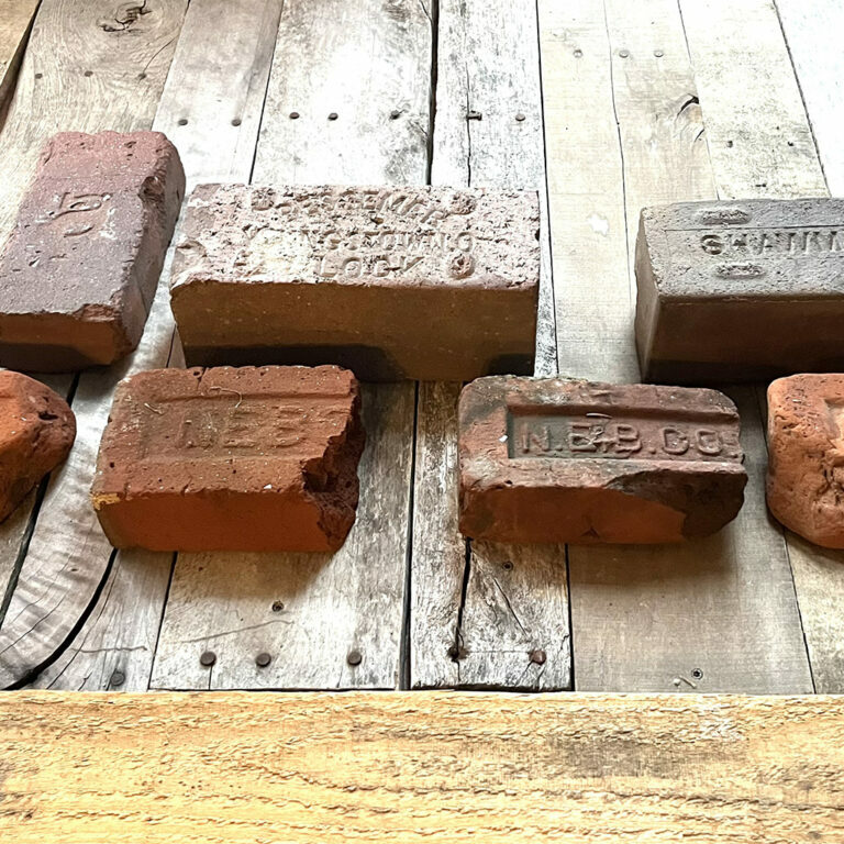 a collection of red bricks on a wood floor